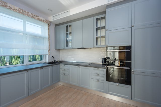 Kitchen with grey cupboards and black countertops